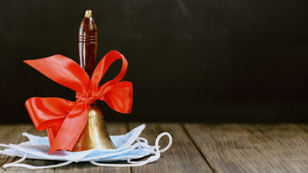 back to school quarantine background. beginning of school year. hand bell on first of September on...