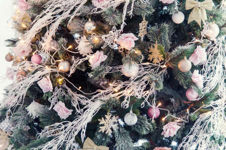 Closeup of Decorated Christmas tree on blurred, sparkling and fairy light background. Happy Holidays. Happy New Year and Xmas greeting card. Copyspace, selective focus.の写真素材