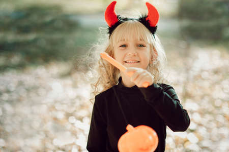 Happy Halloween. Beautiful girl witch. little girl in whitch costume celebrate Halloween outdoor and...