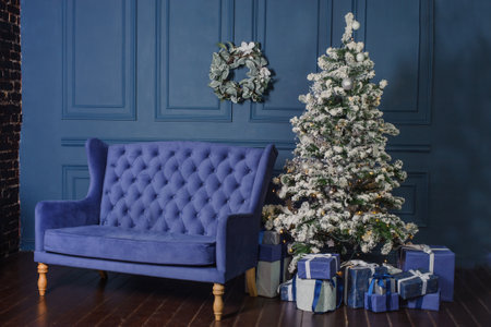 large blue living room with vintage sofa and Christmas tree. Beautiful New Year decorated home interior. blue boxes with gifts near the treeの写真素材