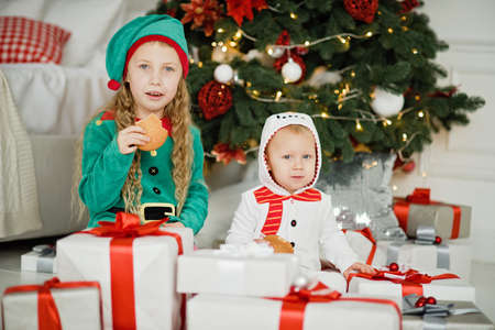 Happy excited girl childen holding christmas gift box. Kids with Christmas present in decorated room. christmas and people concept. New Year Happy holidays. kid satisfied with present.の写真素材