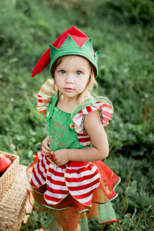 Child waiting for Christmas in wood in juli. portrait of little girl near christmas tree. Baby...