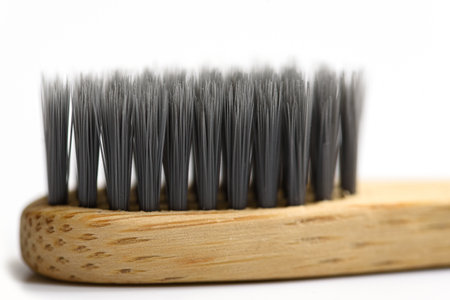 Macro view close up of bamboo toothbrush with black brush bristles. Dental care with eco friendly bamboo tooth brush on white background. Ecology concept. Dental zero waste protection Save the world.の写真素材