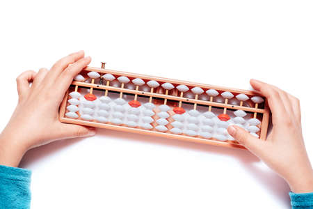 Japanese traditional abacus soroban isolated on white background. Child Hand using abacus. Education and development concept. Back to school, math education, mental mathematics, arithmeticの写真素材