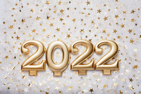 Holiday background Happy New Year 2021. Numbers of year 2022 made by gold candles on bokeh festive sparkling background.の写真素材
