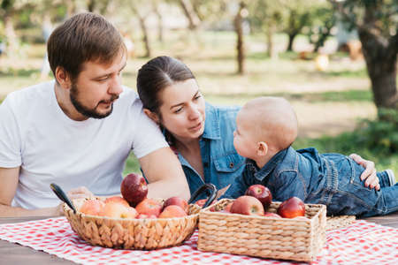 Portrait of Happy family hugging and spending time together outside in green nature. Young mother...