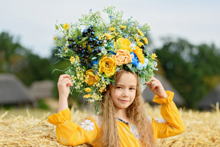 Girl in traditional ukrainian wreath on head blue and yellow flag of Ukraine in field. Ukraine's Independence Flag Day. Constitution day. 24 August. Patriotic holiday.の写真素材