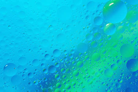 oil with bubbles on light blue turquoise monochrome background. Abstract space background. Soft...