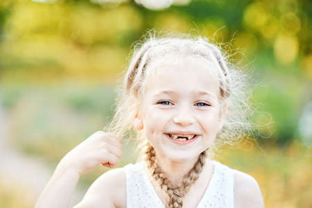 Funny girl with hair plaits. Kid expressing emotions. Close up portrait of beautiful joyful blonde...
