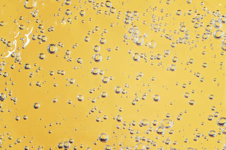 Close up macro Aloe vera gel cosmetic texture yellow background with bubbles. Lemongrass gel skincare product. antibacterial liquid with aloe vera, moisturizing. Serum texture. Hand sanitizerの写真素材