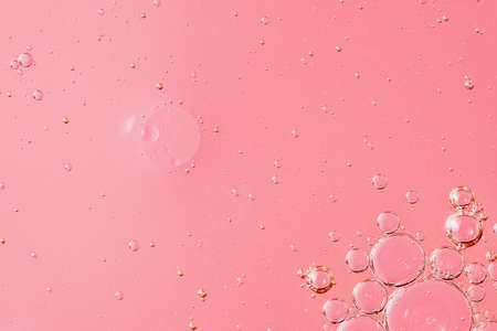 oil with bubbles on light pink coral monochrome background. Abstract space background. Soft selective focus. macro of oil drops on transparent gel surface. copy space. air bubbles in water,の写真素材