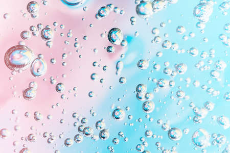 Close up macro Aloe vera gel cosmetic texture pink and blue background with bubbles. Lemongrass gel...