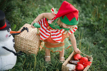Christmas in july. Child waiting for Christmas in wood in july. portrait of little girl decorating...