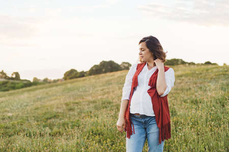 Outdoor Lifestyle portrait of pregnant woman expecting baby at sunset in nature. Expecting belly. Concept of pregnancy, maternity. Freedom concept. Enjoyment. Young woman relaxing enjoying fresh airの写真素材