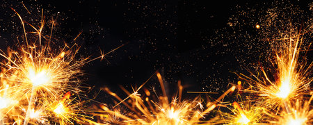 festive new year sparklers and bokeh lights on black background. soft selective focus. abstract bokehholiday background, copy space. Christmas or New Year composition. Christmas card. banner panoramaの写真素材
