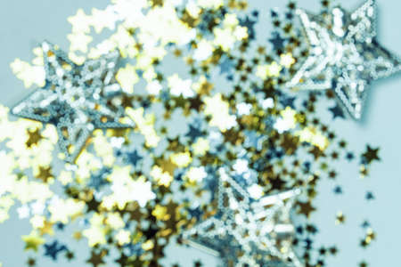 Holiday Festive background. gold and silver star confetti glitter scattered on blue background....