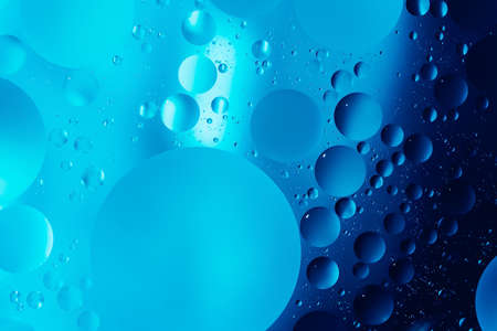 oil with bubbles on dark blue background. Abstract space background. Soft selective focus. macro of oil drops on water surface. copy space. air bubbles in waterの写真素材