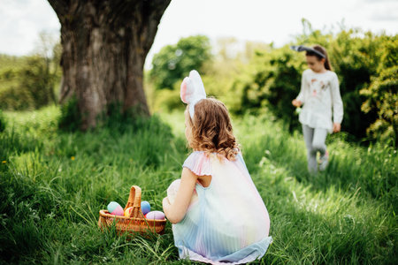 Easter egg hunt. Group Of Children Wearing Bunny Ears Running To Pick Up colorful Egg On Easter Egg...