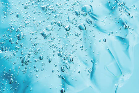 Close up macro Aloe vera gel cosmetic texture blue background with bubbles. Lemongrass gel skincare product. antibacterial liquid with aloe vera, moisturizing. Safe and environmental friendly.の写真素材