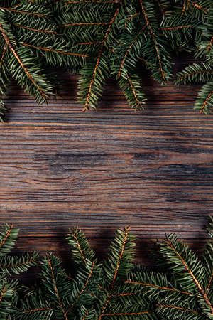 Christmas wooden rustic background with fir tree. Wooden background. Flat lay, top view, copy space. Xmas or New Year greeting card. Xmas wooden background with green pine branches. Holiday frameの写真素材