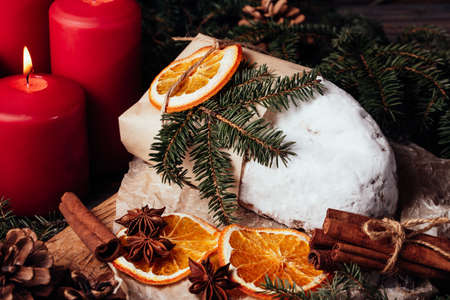 Christmas stollen on wooden background. Traditional christmas german dessert cut into pieces. Cake with nuts, raisins with marzipan and dried fruit on cutting board. baking for xmasの写真素材