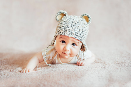 Newborn child relaxing in bed after bath or shower. Nursery for children. Textile and bedding for kids.の写真素材
