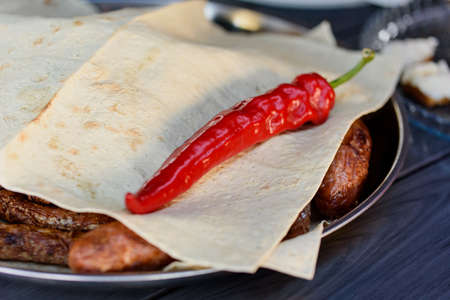 Grilled sausages or bratwurst with red chili peper. Delicious german sausages barbecue grill. summer...