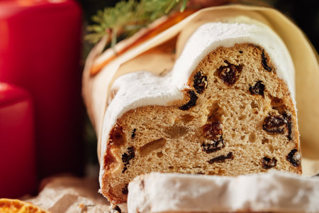 Christmas stollen on wooden background. Traditional christmas german dessert cut into pieces. Cake with nuts, raisins with marzipan and dried fruit on cutting board. baking for xmasの写真素材