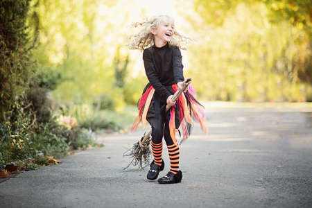 Beautiful girl witch. little girl in witch costume celebrate Halloween outdoor and have fun. Kids...