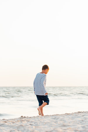 summer vacation at sea. Boy at seaside. Child collect shells on beach having fun during summer holiday. happy kid playing at sunset time. Happy childhood. Travel and adventure conceptの写真素材