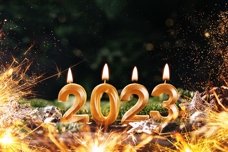 Holiday background Happy New Year 2023. Numbers of year 2023 made by gold burning candles on bokeh...