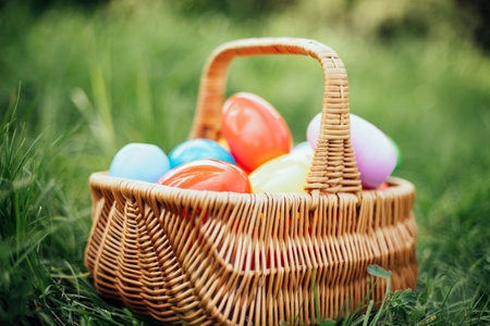 Colorful easter eggs in basket on green grass outdoor. Easter background concept. egg hunt.の写真素材