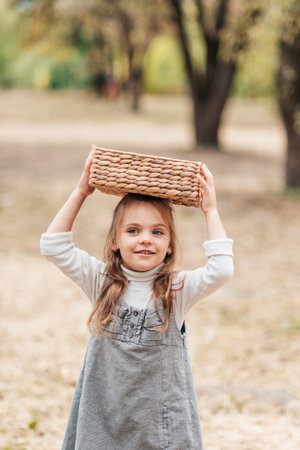 Child picking pears on farm in autumn. Little girl playing in pears tree orchard. Healthy nutrition. Cute little girl eating red delicious pear. Harvest Concept. pears picking.の写真素材