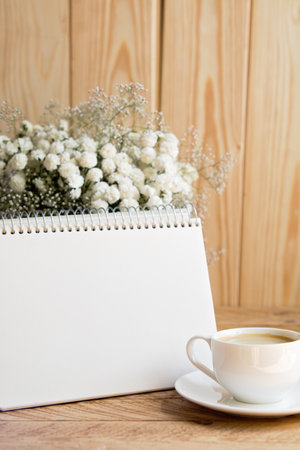Morning cup of coffee with paper notepad on wooden table. Morning coffee mug for breakfast, empty notebook with vintage filter effect. copy space. planner mockup. Cozy work spaceの写真素材