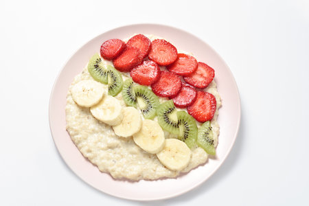 Concept of food for healthy breakfast. oatmeal with bananas, kiwi and strawberry on light background. Top view. Copy spaceの写真素材
