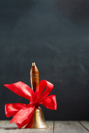 back to school background. beginning of school year. hand bell on first of September on blackboard backgroundの写真素材