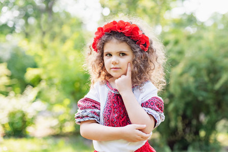 Girl in traditional ukrainian wreath on head blue and yellow flag of Ukraine in field. Ukraines Independence Flag Day. Constitution day. 24 August. Patriotic holiday.の写真素材