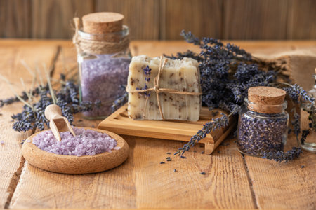 Wellness treatments with lavender flowers on wooden table. Spa still-life. Essential oils, sea salt, towels and handmade soap. Natural herb cosmetic with lavender flowersの写真素材