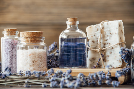Wellness treatments with lavender flowers on wooden table. Spa still-life. Essential oils, sea salt and handmade soap. Natural herb cosmetic with lavender flowersの写真素材