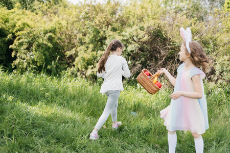 Easter egg hunt. Group Of Children Wearing Bunny Ears Running To Pick Up colorful Egg On Easter Egg...