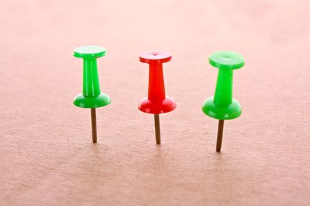 Three colourful pins on cardboardの写真素材