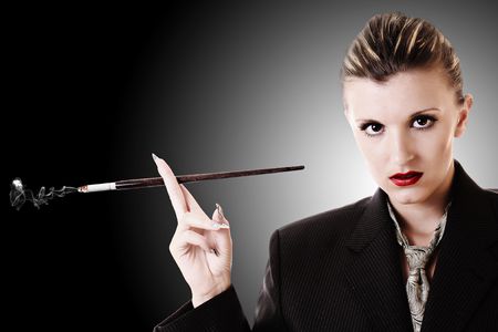 Woman with cigarette holder in office suiteの写真素材