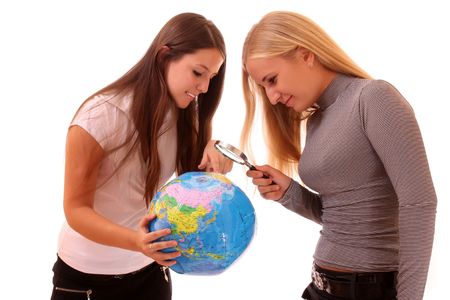 Two happy young girls with globe on whiteの写真素材