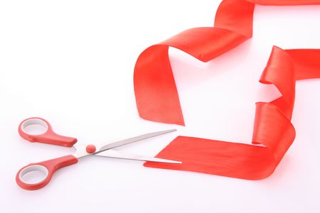 Red ribbon with scissors isolated on whiteの写真素材