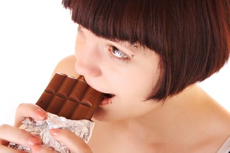 Young beautiful glutton eat chocolate isolated on whiteの写真素材
