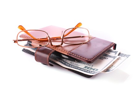 Glasses, notebook and dollar banknotes isolated on whiteの写真素材