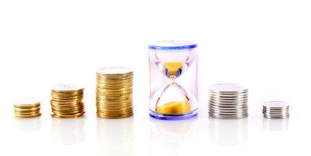 Coins and sand clock isolated on white