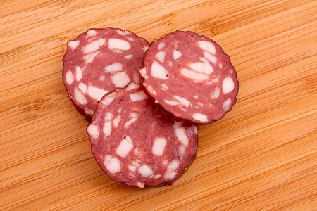 Sausage and bread on wooden surface