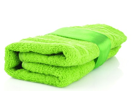 Folded green towel with the band isolated on whiteの写真素材