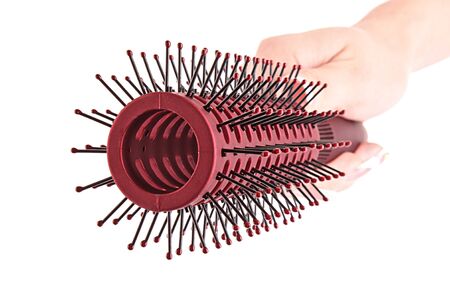 Hairbrush in hand isolated on whiteの写真素材